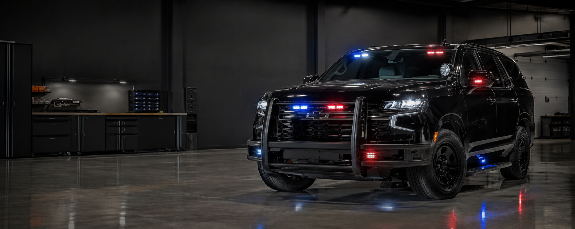 Black public safety SUV professionally equipped with emergency lighting in a clean upfit bay
